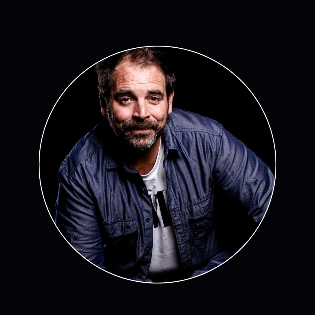 Chris Miller Australian voiceover artist - Man wearing a blue shirt with a black background